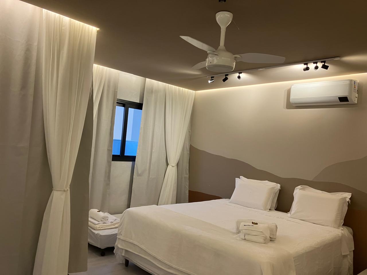 Suíte Areia com cortinas fluidas e iluminação cênica