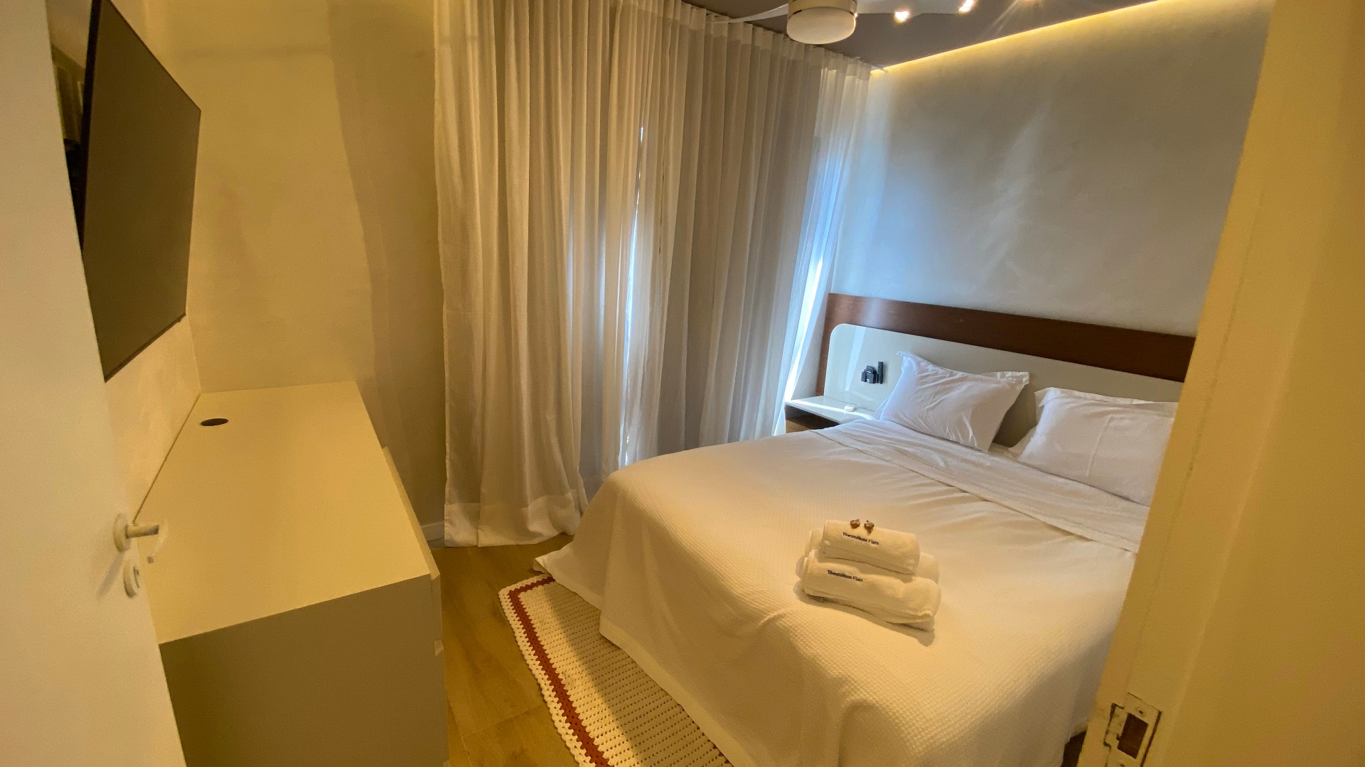 Suíte com cortinas brancas translúcidas e cama king
